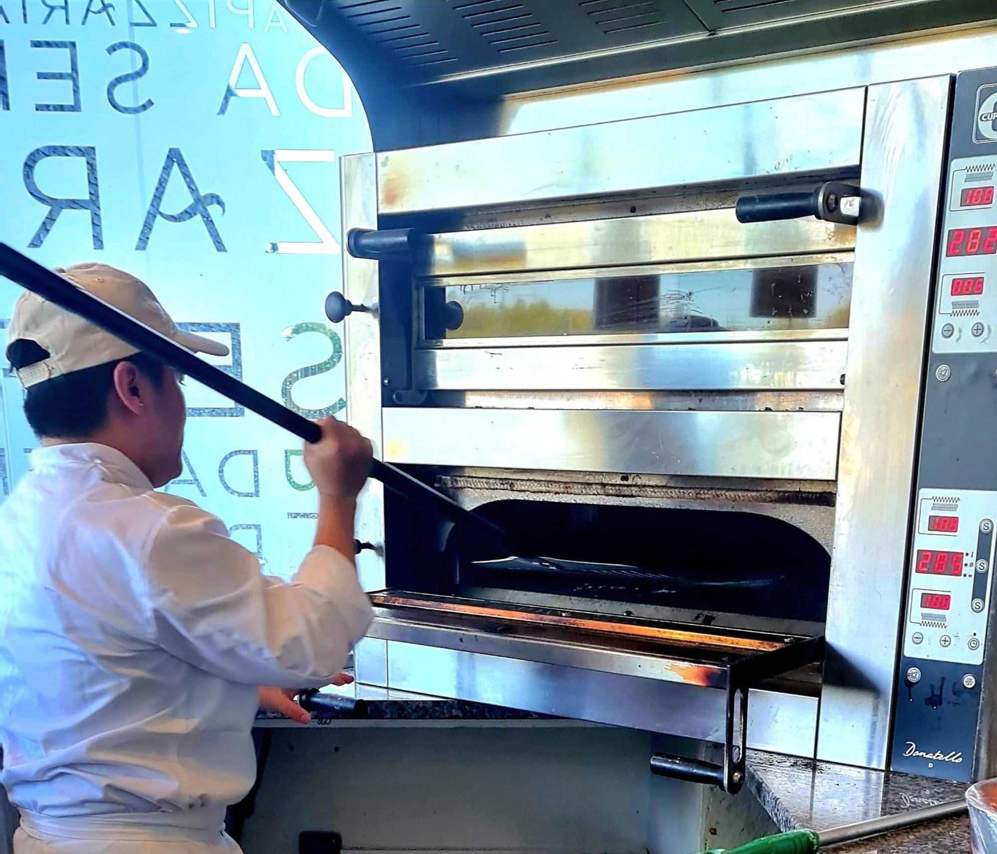 Monchique Resort & Spa Bagian luar foto A pizzaiolo baking a pizza in a wood-fired oven